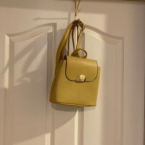 No brand name. Purse/backpack mustard 7 inches tall 8.5 wide 4 inches deep.